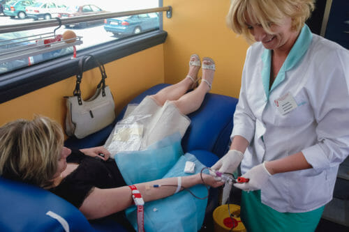 Lady donating blood with a nurse