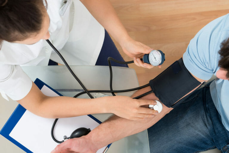 Overhead view of woman taking mans vitals