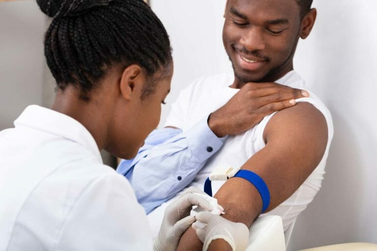 Woman practitioner drawing man's blood