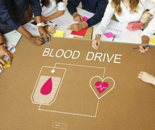 People sitting around a blood drive planning board